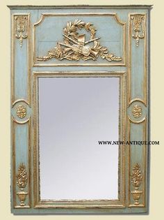 an ornately decorated mirror with gold trimmings and blue paint on the frame