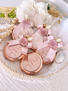 three personalized wedding favors on a plate with flowers and pearls in the back ground