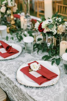 the table is set with red napkins and place settings