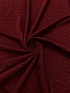 a close up view of a red fabric with hexagonal design on it,