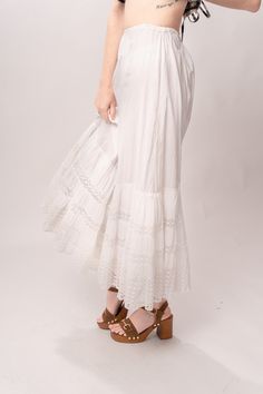 Enchanting Edwardian 1910’s white cotton petticoat maxi skirt with tiered tatted lace, a full skirt, and drawstring waist. Great vintage condition, with normal wear and condition for its age. Some faint spots and visible mending. Best fits modern size S/M Length 37”Waist up to 30” Featured top is the Gingham Graham Top from our friends at Psychic Outlaw. Model’s Measurements:Height 5’9”Chest 34”Waist 29”Hips 36.5” Bohemian Long Skirt For Daywear, Lace Trim Maxi Skirt For Wedding, Bohemian Gathered Maxi Skirt For Daywear, Summer Maxi Bottoms With Lace Trim, Daywear Long Lace Skirt, White Bottoms With Lace Trim Full Skirt, Summer Maxi Length Bottoms With Lace Trim, White Bottoms With Attached Cancan For Spring, Peasant Style Ruffled Tiered Skirt Bottoms