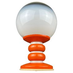 an orange and white object is on top of a stand with a ball in the middle