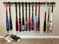 a baseball bat and glove hanging on a wall next to a pair of shoes in a room