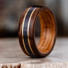 a wooden ring with black and gold inlays