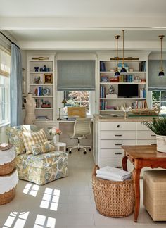 a living room filled with furniture next to a window covered in blinds and bookshelves