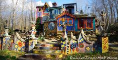 an elaborately painted house in the woods with stairs leading up to it's entrance