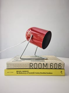 a red lamp sitting on top of a book next to a yellow book with the word room 666