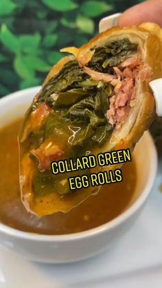 a hand holding a sandwich over a bowl of soup with the words collard green egg rolls