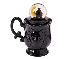 a black coffee mug with a glass ball in it