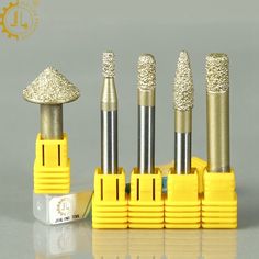 four different types of drill heads in yellow holders