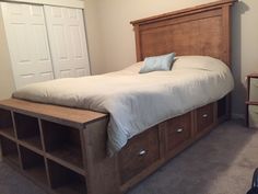 a bed sitting in a bedroom next to a wooden headboard and foot board with two drawers