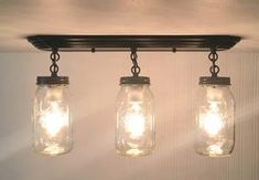 three mason jar lights hanging from the ceiling