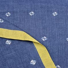 a blue and yellow fabric with small white dots on it