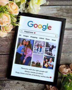 a photo frame sitting on top of a wooden table next to flowers