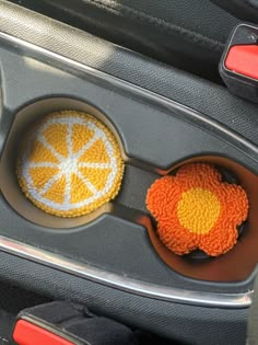 two cupcakes in a muffin tin with orange and white frosting on them