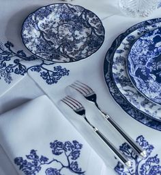 a blue and white table setting with silverware