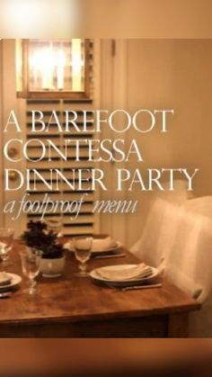 a wooden table with plates and glasses on it in front of a window that says barefoot contessa dinner party