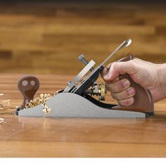 a person is using a small machine to cut wood with a pair of tongs