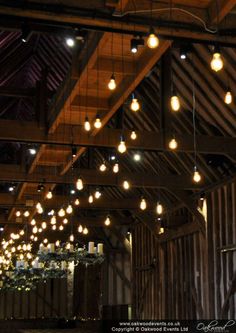 a barn with lots of lights hanging from the ceiling