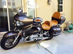 a motorcycle parked in front of a house with two seats on the back and side