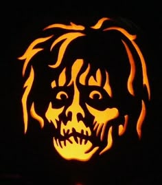 a carved pumpkin with an image of a man's face in the center, on a black background