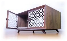 a wooden cabinet with an intricate design on the front and sides, sitting on top of a hard wood floor