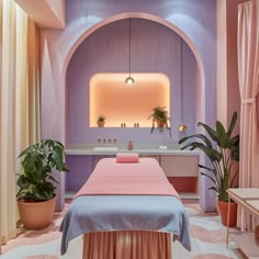 a pink and blue spa room with a large bed, potted plants and two sinks