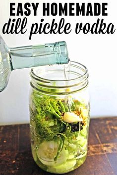 a mason jar filled with homemade dill pickle vodka is being poured into it