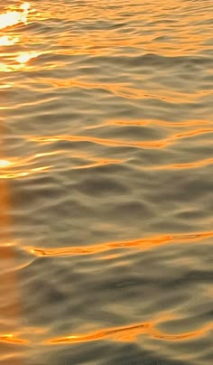 the sun is setting over the water with ripples