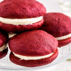 red velvet cookies with cream filling on a glass plate