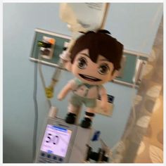 a stuffed toy is sitting on top of a medical machine in a room with blue walls