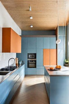 a modern kitchen with blue cabinets and wood flooring