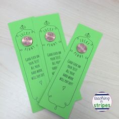 two green bookmarks with pink buttons on them