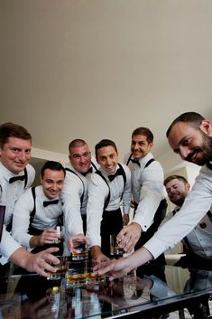 a group of men standing around a glass table