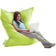 a woman sitting in a pink bean bag chair with her laptop computer on her lap