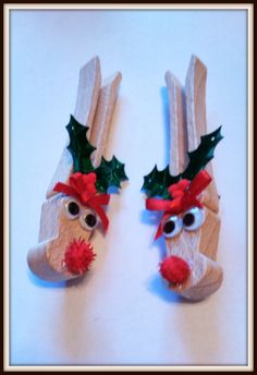 two wooden reindeers with red noses and green leaves