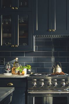 a stove top oven sitting inside of a kitchen next to a counter with pots and pans on it