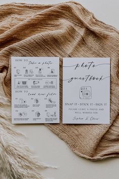 the wedding stationery is laid out on top of a brown blanket with white writing