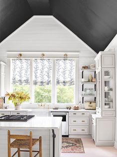 a kitchen with white cabinets and an island in front of a window that reads farmhouse fix - up