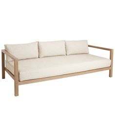 a white couch with four pillows sitting on it's back legs and armrests