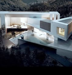 an aerial view of a modern house in the middle of a mountain range at night