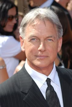 an older man in a suit and tie posing for the camera on the red carpet