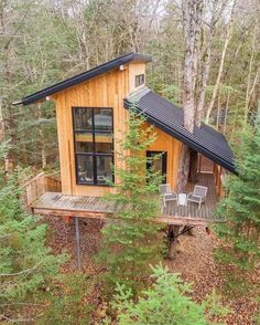 a small wooden cabin in the woods surrounded by trees