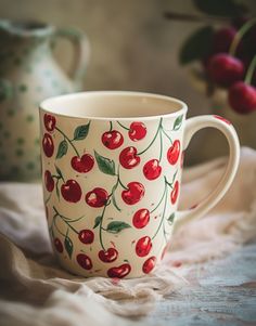 a coffee cup with cherries painted on it