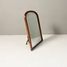 a wooden mirror sitting on top of a white table