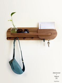 a wooden shelf with sunglasses and a purse hanging on it's side next to a plant