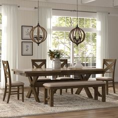 a dining room table and bench in front of a window