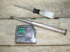 two tools are sitting on top of a wooden table