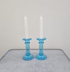 two blue candles sitting on top of a table