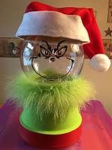 a christmas hat on top of a glass ball with a grin face painted on it